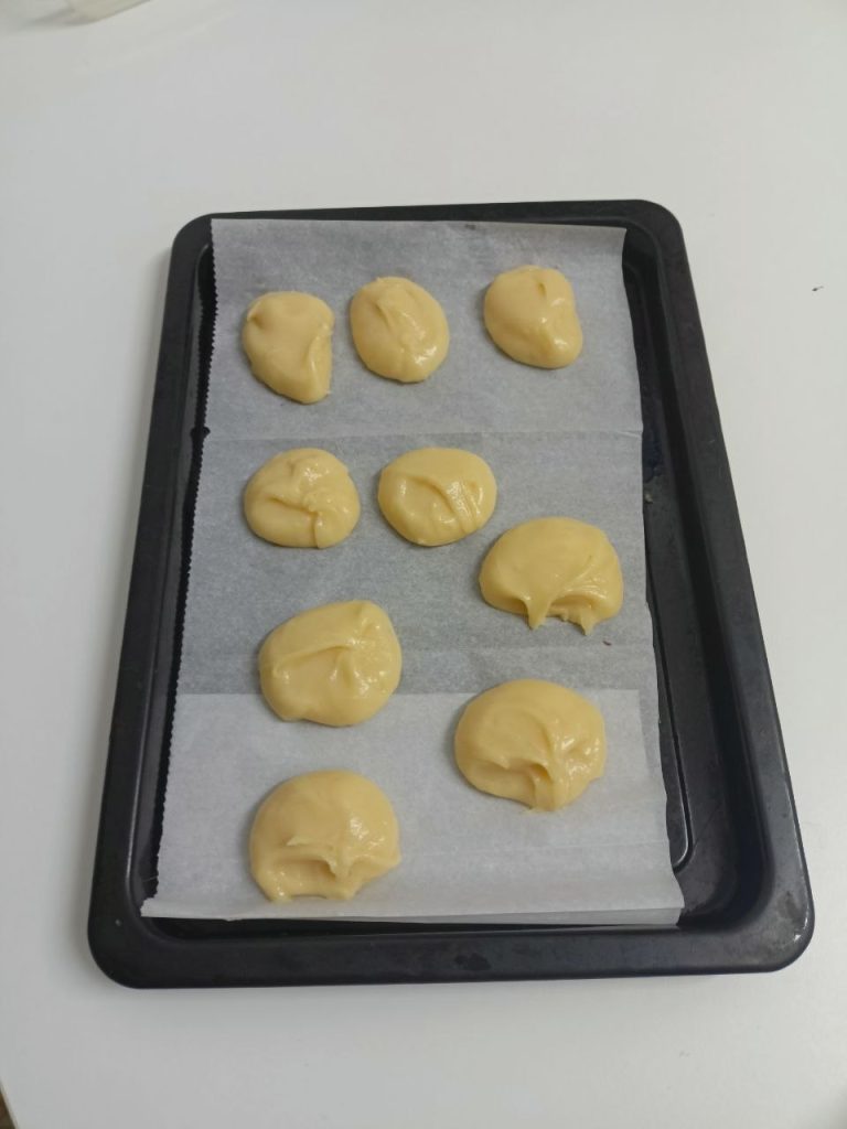 piped choux pastry dough on baking tray