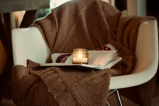 textured blanket, book and mug on a sofa